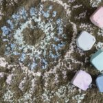 homemade chalk next to a sun design on a rock